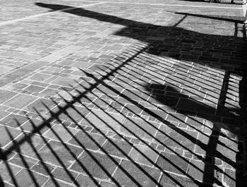 High angle view of shadow on footpath by street