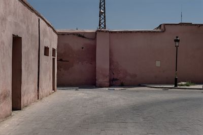 Empty road by building against sky