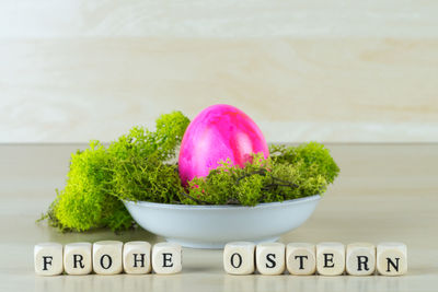 Close-up of text by easter eggs and vegetable on table