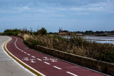 Road by plants against sky