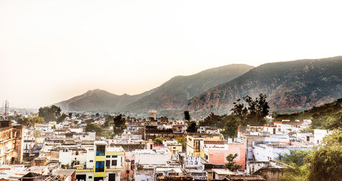 Town by mountains against clear sky