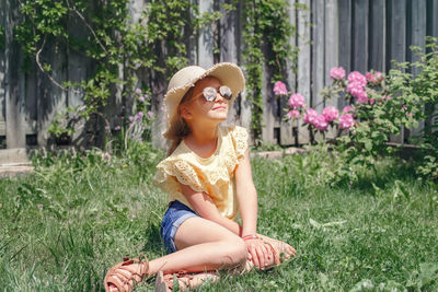 Girl sitting in grass at yard