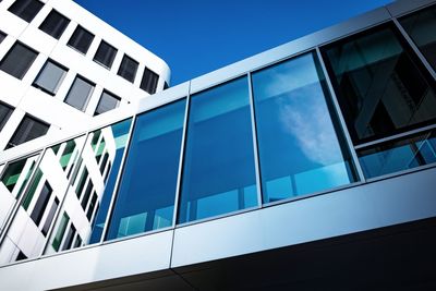 Low angle view of modern building against blue sky