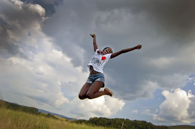 Woman jumping against sky