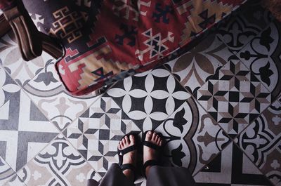 Low section of woman standing on tiled floor at home