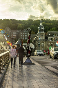 Rear view of people walking on street in city