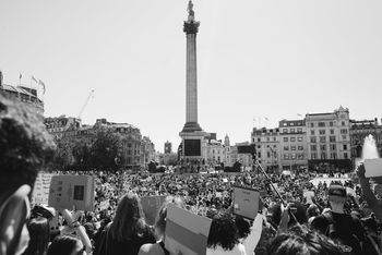 GROUP OF PEOPLE IN FRONT OF BUILDINGS IN CITY