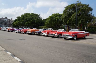 Cars on road in city against sky