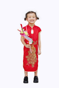 Portrait of smiling girl standing against white background