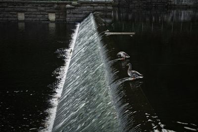 Blurred motion of man splashing water in river