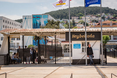 Man walking on footpath against buildings in city