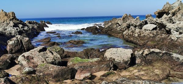 Scenic view of rocky beach against sky