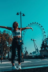 Full length portrait of woman standing at amusement park