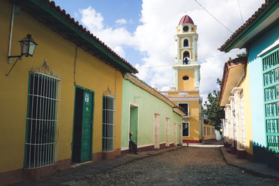 Footpath leading towards church bell tower by houses