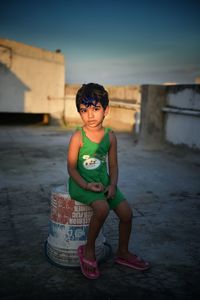 Boy smiling while standing on beach against sky