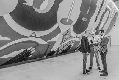 Low section of people standing against wall