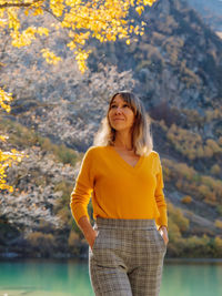 Young woman standing against mountain