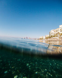 Surface level of sea against clear blue sky