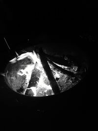 Close-up of illuminated lamp over black background