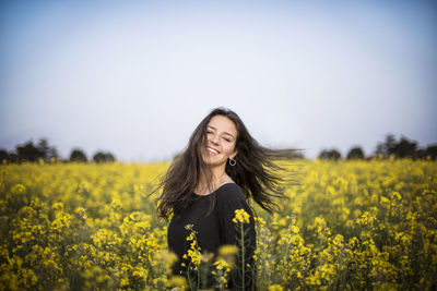 Beautiful young woman standing in field