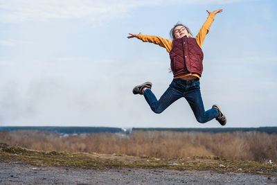 Full length of girl  jumping against sky