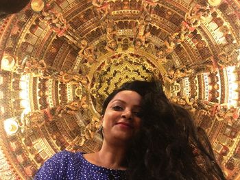 Low angle view of woman looking at illuminated ceiling