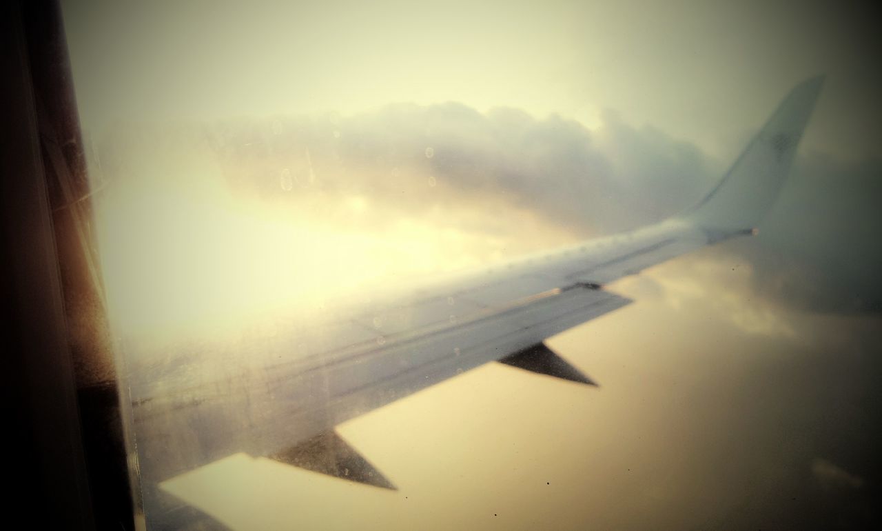 airplane, flying, air vehicle, aircraft wing, mode of transport, transportation, part of, mid-air, sky, cropped, travel, on the move, cloud - sky, journey, nature, no people, sunlight, aircraft, day, cloud