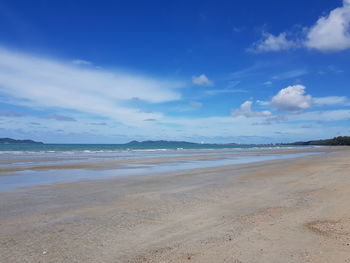 Scenic view of beach against blue sky