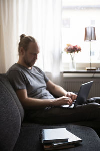 Man using laptop on sofa