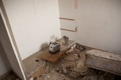 Abandoned chair on floor against wall at home