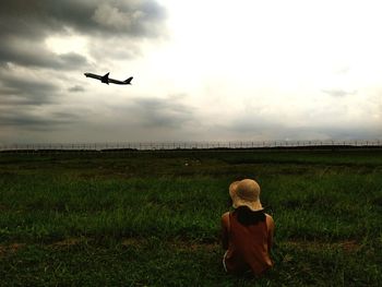 Rear view of birds flying over field