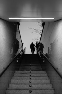 Rear view of people walking on staircase