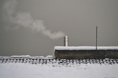 Smoke emitting from chimney on snow