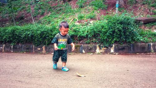 Full length of boy with girl standing against plants