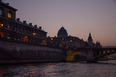 Arch bridge over river against buildings in city