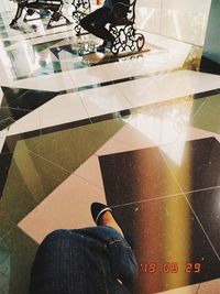 Low section of man standing on tiled floor