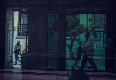 Side view of man walking by building in city