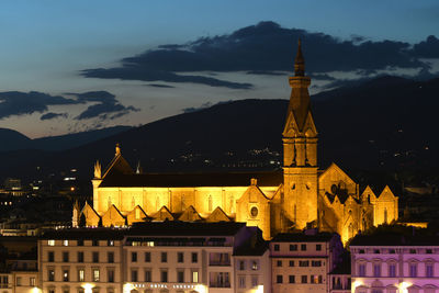 Illuminated buildings against sky at dusk