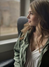 Woman looking away while seated near window