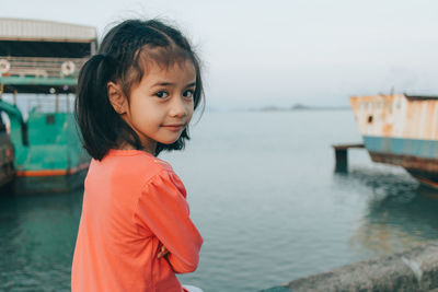 Portrait of smiling girl standing at sea shore