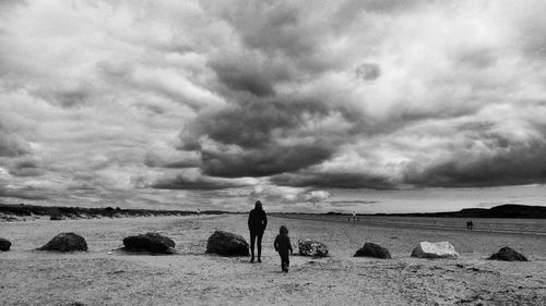 Rear view of woman and child on beach