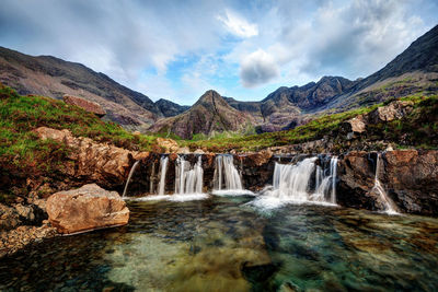 Scenic view of waterfall against sky