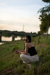 Side view of woman sitting on field