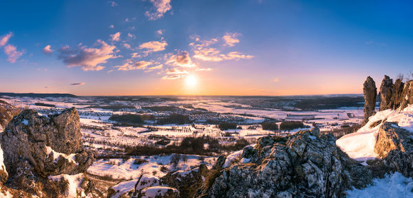 Scenic view of winter landscape against sky during sunset