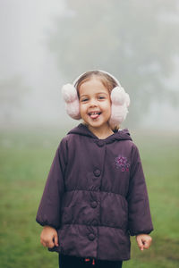 Portrait of smiling girl standing on field