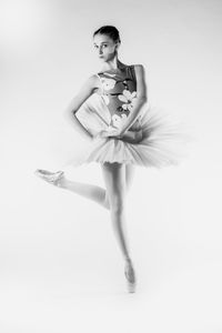 Young woman dancing against white background