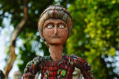 Close-up portrait of statue against trees