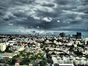 High angle view of buildings in city against storm clouds