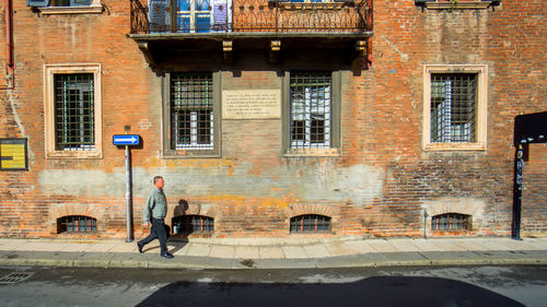 Man walking on street against building