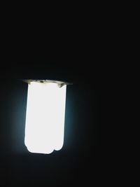 Low angle view of illuminated window in darkroom